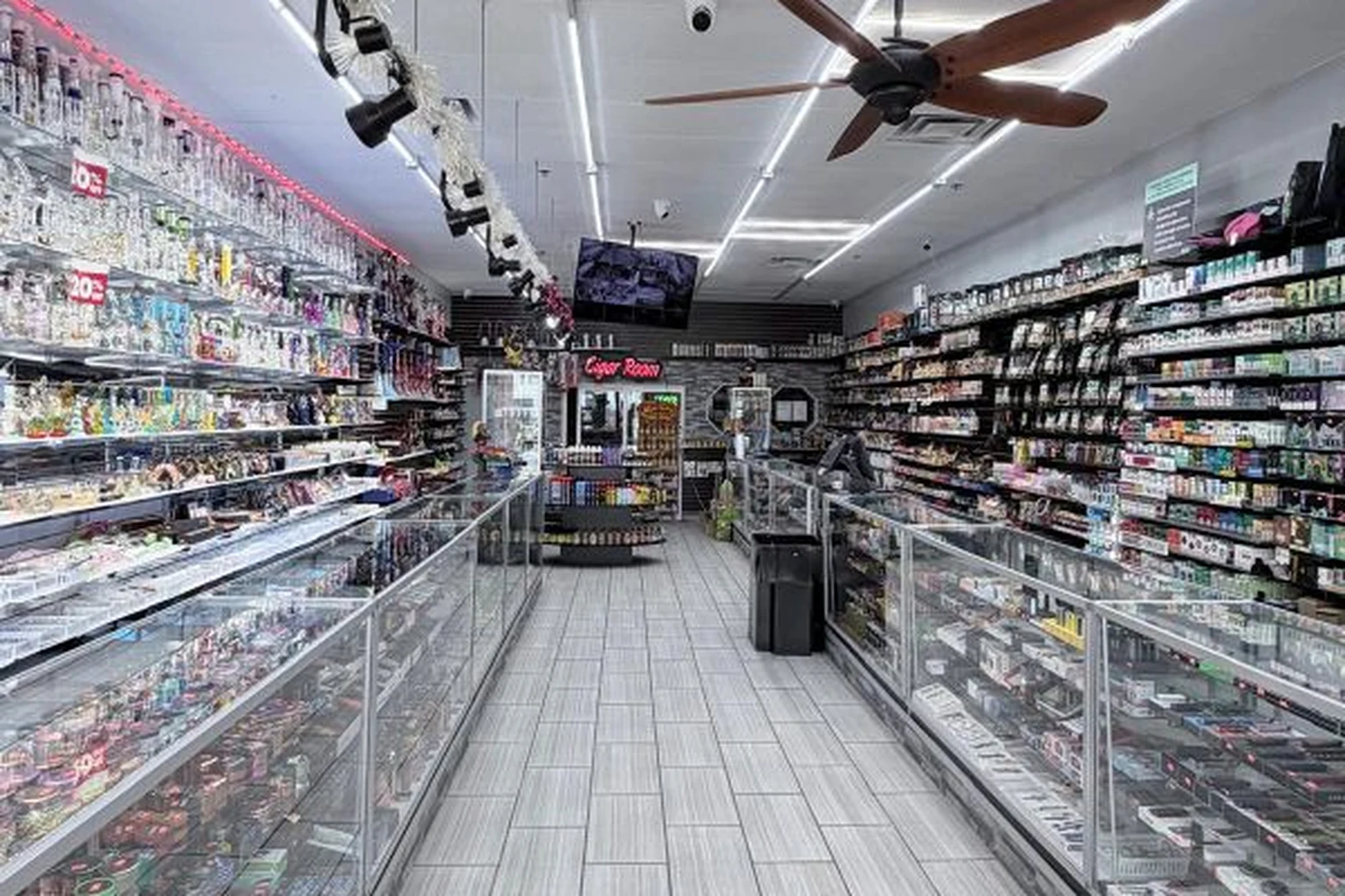 Store aisle with glass display cases and the cigar room at Midwest Smoke Shop on Dodge Street