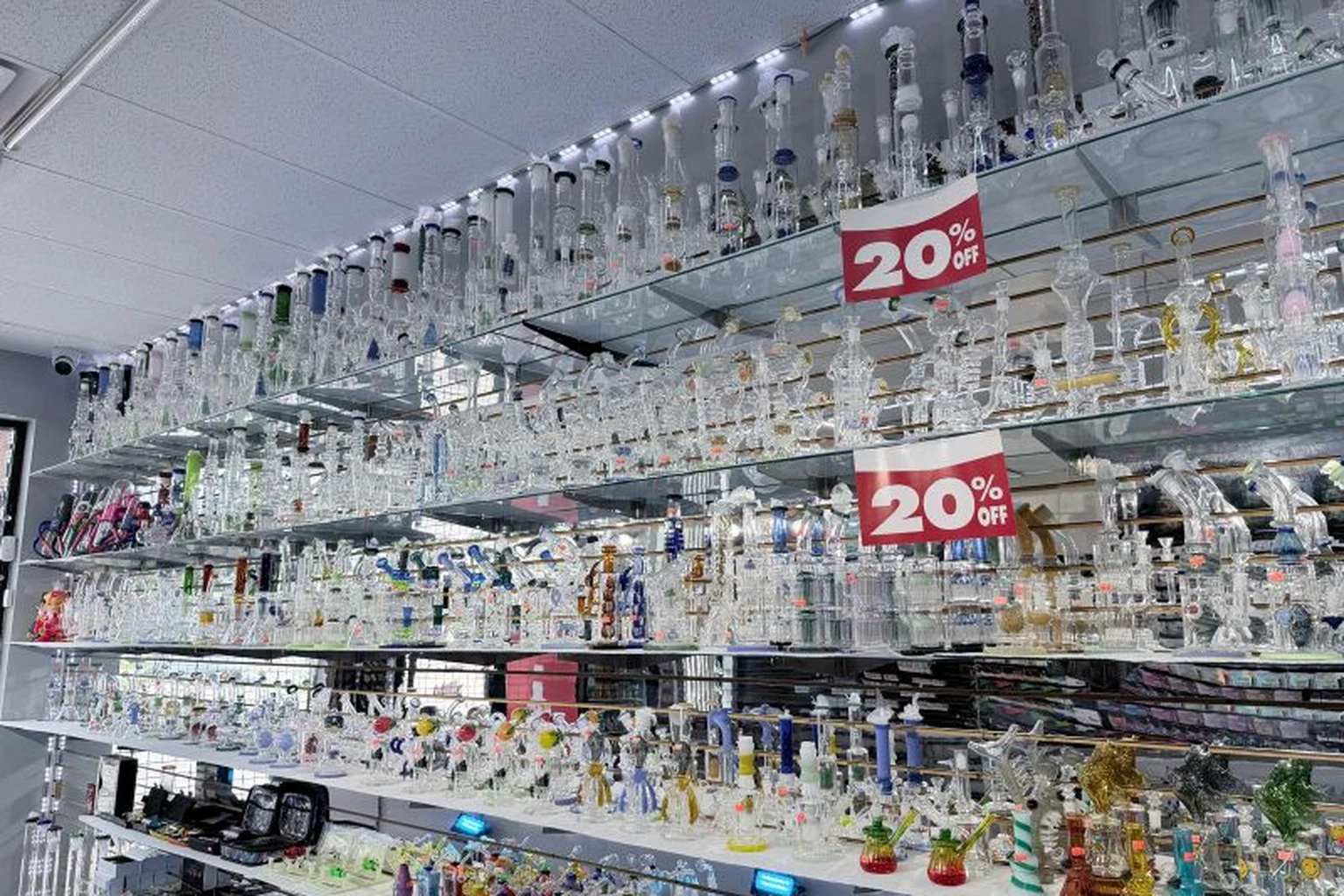 Glass water pipe wall with promotional signage at Midwest Smoke Shop on Dodge Street